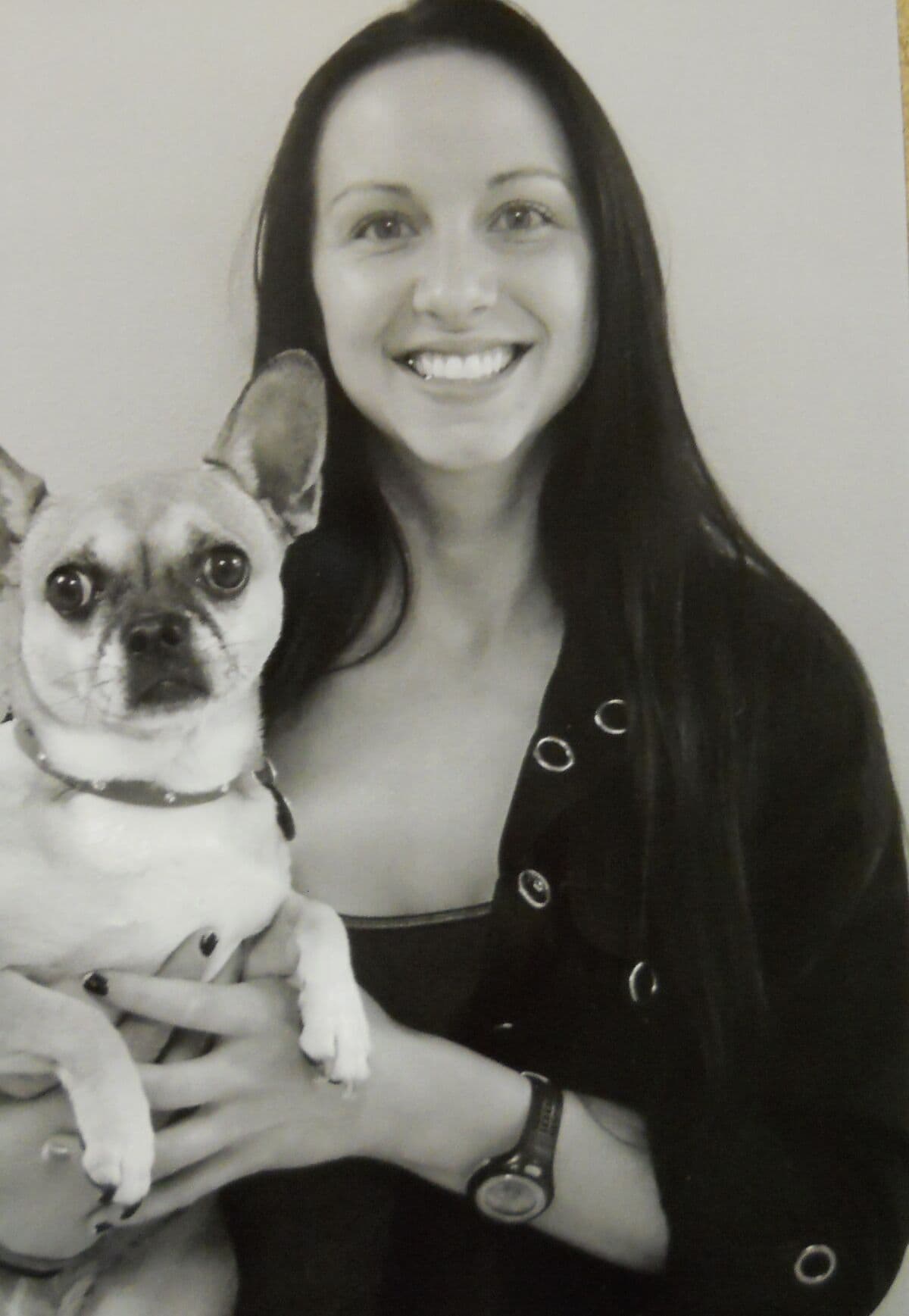 Black and white portrait of Kelsea holding a small pug-mix dog