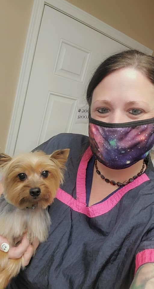A tech snaps a selfie with a Yorkie in her arm