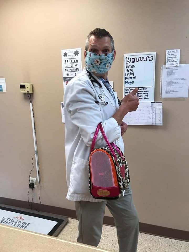 A doctor carries a patient out in her leopard-print tote